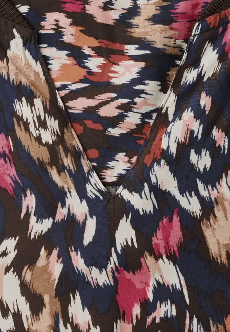 Tissu coloré à motif animalier abstrait en tons marron, bleu marine, blanc et rose, texture subtile.