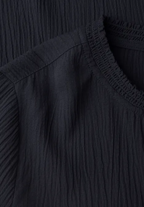 Langarm Blusenshirt mit Smokdetails urban dark blue Nahaufnahme schwarz gerippten Stoffes mit feiner Textur und angedeutetem V-Ausschnitt