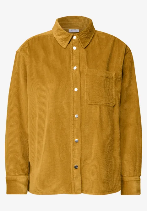 Chemise en velours côtelé moutarde avec patte de boutonnage et poche poitrine.