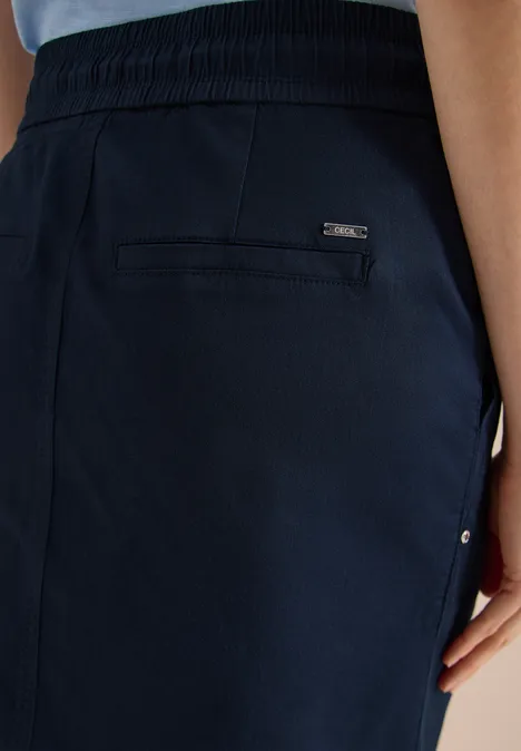 Fokus auf die Rückseite dunkelblauer Hose mit Gummibund und eingelassener Tasche.