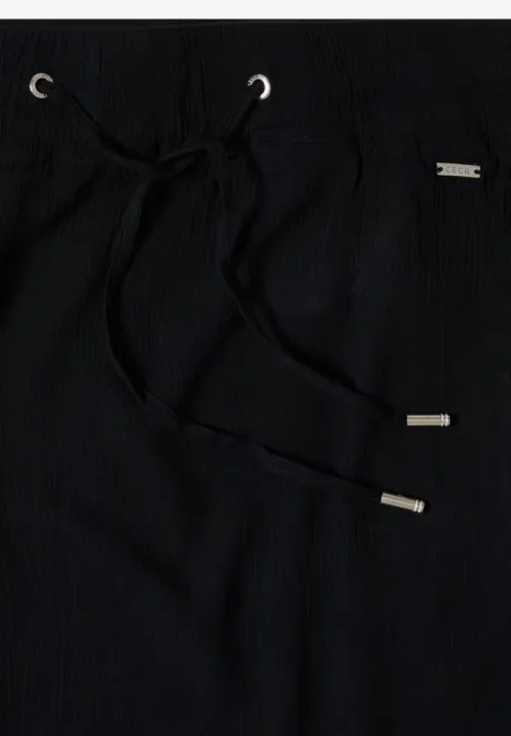 Schwarze Stoffhose mit Kordelzug und silbernen Metallenden.