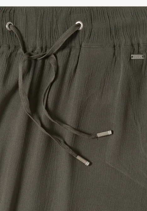 Dunkelgrüne, strukturierte Hose mit elastischem Bund, silbernen Ösen und lässigem Kordelzug.