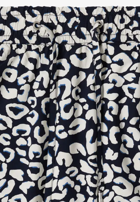 Elastisch geraffter dunkelblauer Stoff mit weißem, abstraktem Leopardenmuster.