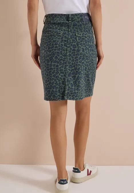 Kniehoge denimrok met luipaardprint dried olive green Achteraanzicht van een persoon met groene-blauwe luipaardkokerrok tot op de knie en witte sneakers.