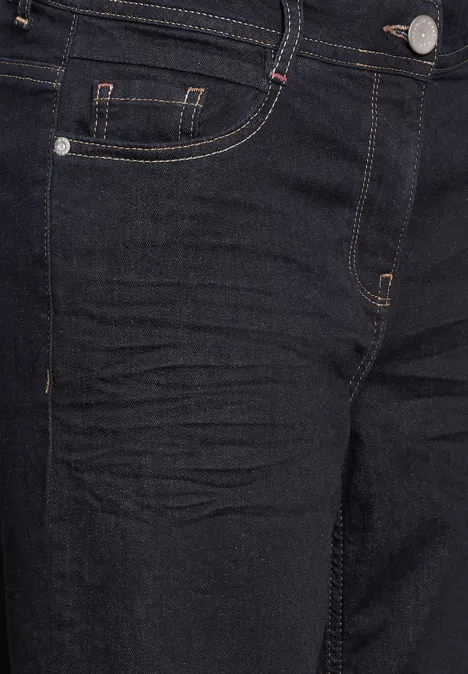 Gros plan sur un jean foncé avec coutures jaunes et petite poche.