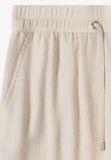 Pantalon beige en lin avec taille élastiquée, cordon de serrage et poches latérales, décontracté et léger