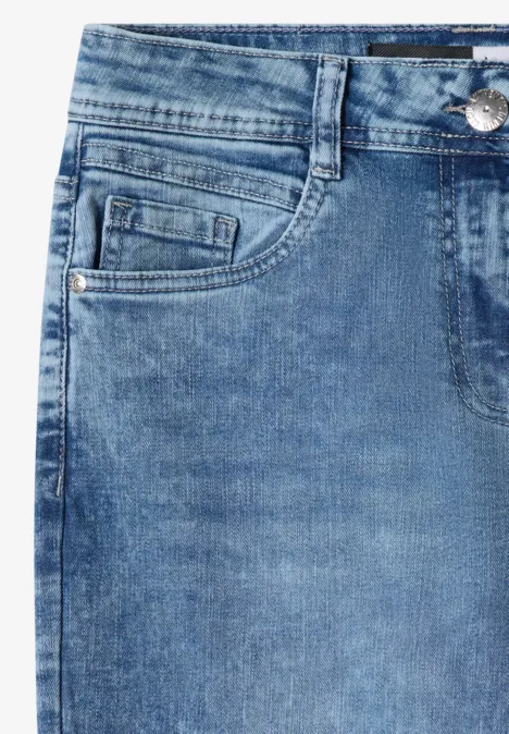 Detailaufnahme blauer Jeans mit vorderer Tasche, Münztasche, Gürtelschlaufen und Nahtverarbeitung.