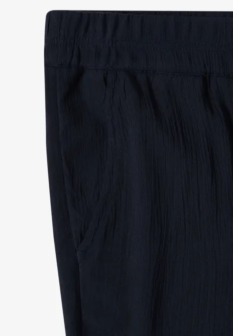 Zwarte, gestructureerde broek met elastische tailleband en zijzakken.