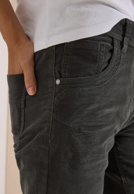 Hand in der vorderen Tasche einer anthrazitfarbenen Cordhose
