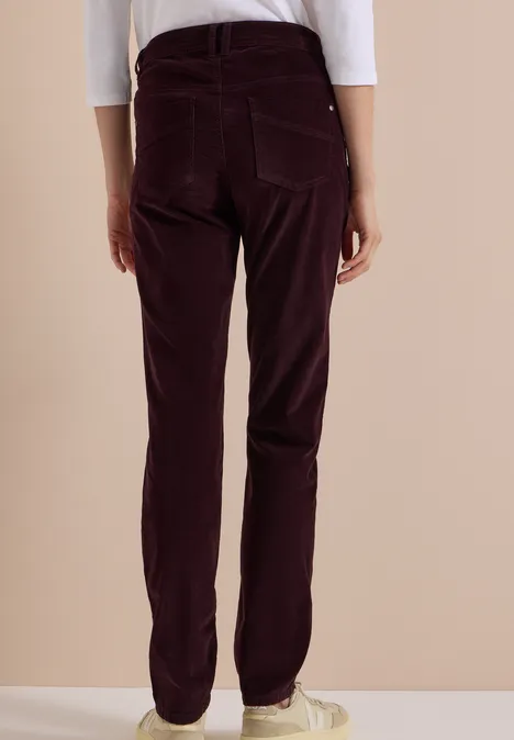 Personne vue de dos, portant un pantalon en velours côtelé violet foncé, coupe droite.