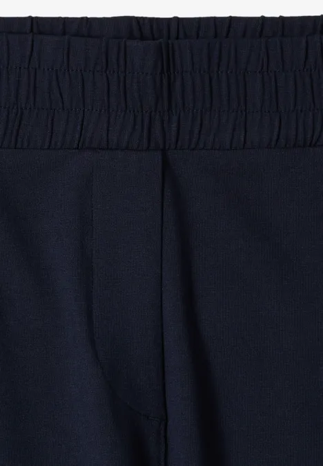 Nahaufnahme eines marineblauen Hosenbunds mit elastischem Taillenbereich.