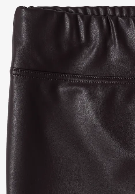 Zwarte, hoog getailleerde rok van kunstleer met elastische tailleband.