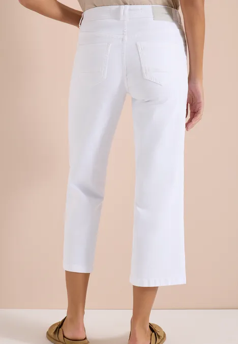 Wide Leg Jeans mit Patch Pockets White Rückenansicht einer Person in weißen, knöchellangen, weiten Jeanshosen vor neutralem Hintergrund.