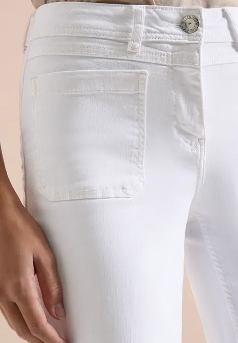 Wide Leg Jeans mit Patch Pockets White Nahaufnahme einer weißen, eng anliegenden Jeans mit Fronttasche und Hand am Oberschenkel.