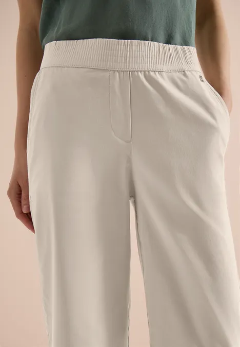 Beige katoenen broek met elastische taille en zijzakken, casual en comfortabel.