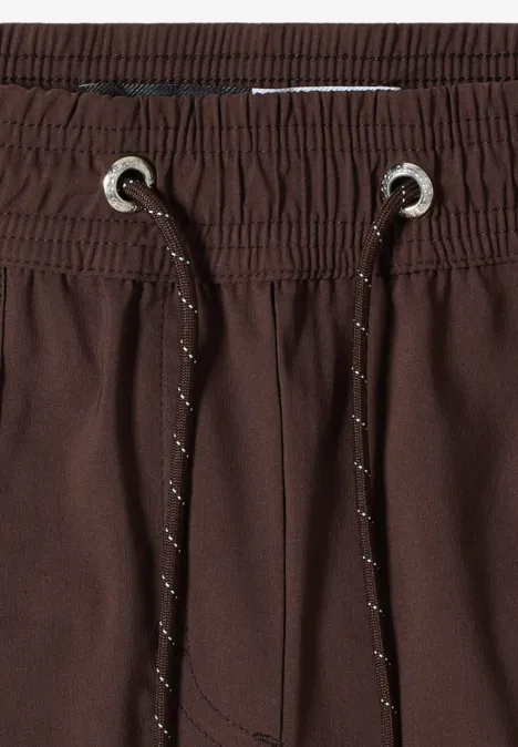 Straight Legs shorts in een Loose Fit brown cacao Close-up van een bruine broek met elastische tailleband en trekkoorden.