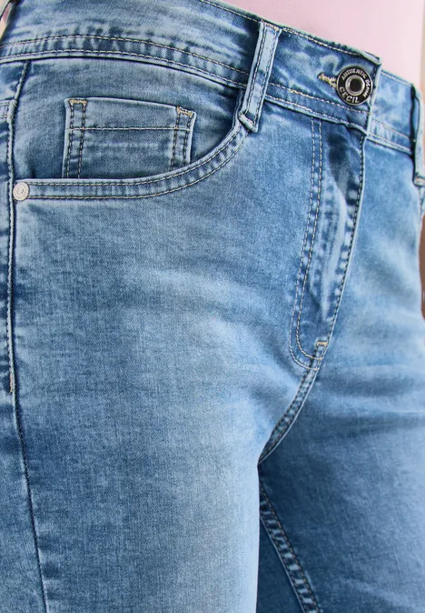 Nahaufnahme der Taille und Oberschenkel in hellblauen Jeans mit Tasche und Gürtelschlaufen.
