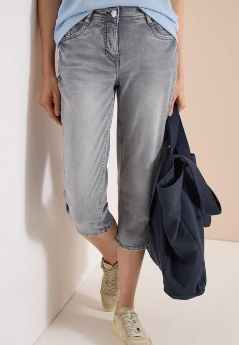 3/4 Slim Leg Jeans im Casual Fit mid grey used wash Graue Capri-Jeans, leger hochgekrempelt, weiße Sneaker, dazu blaue Tasche.