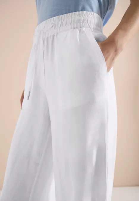 Weiße, weite Leinenhose mit Gummibund und Seitentaschen.