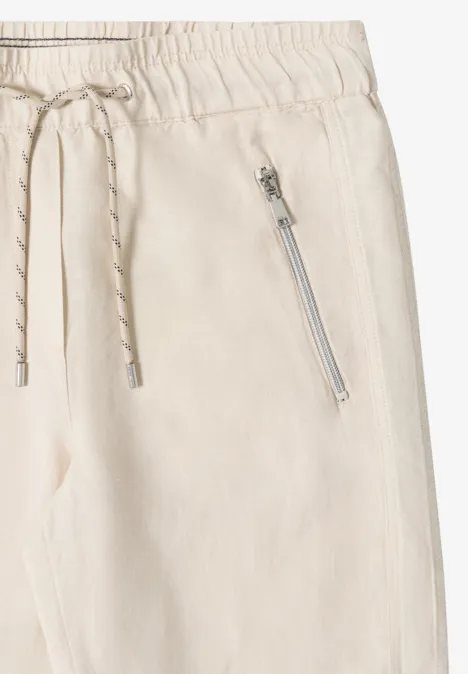 Helle, bequeme Stoffhose mit Elastikbund, Kordelzug und seitlicher Reißverschlusstasche.