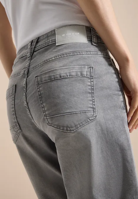 Slim Leg Jeansshorts im Casual Fit mid grey used wash Person in grauen Jeans und weißem Top von hinten, Fokus auf Gesäßbereich.