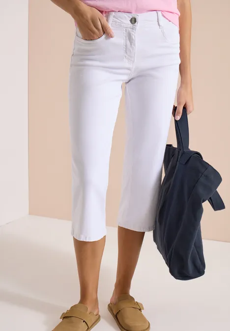 Wide Leg 3/4 Jeans im Loose Fit White Weiße Capri-Jeans kombiniert mit einem pastellfarbenen Top, legeren Loafers und einer dunkelblauen Jacke.