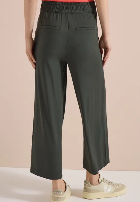 Damen-High-Waist-Hose in Olivgrün, weite 7/8-Beinform, hinten mit angedeuteten Taschen.