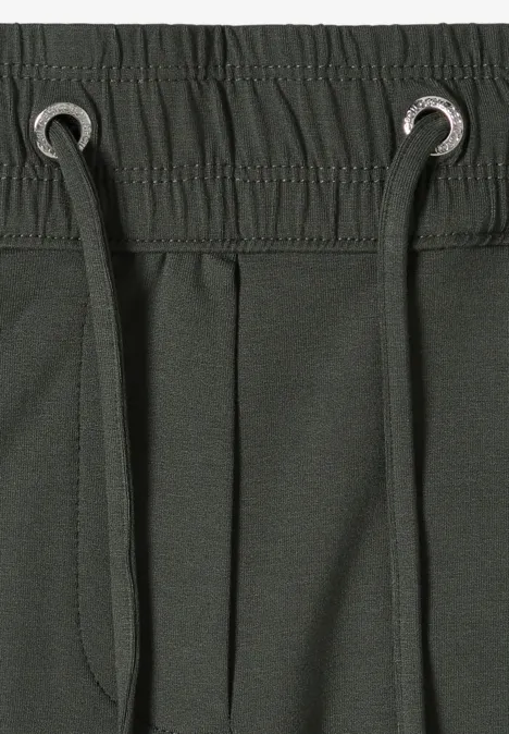 Dunkelgrüne Sweatpants mit elastischem Bund, Tunnelzug und Ösen, mit seitlicher Tasche.