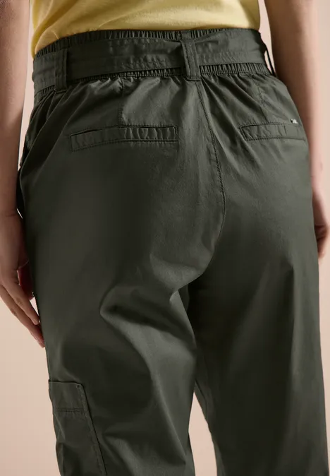 Rückansicht einer Person in olivgrünen Cargo-Hosen mit elastischem Bund und Taschen.