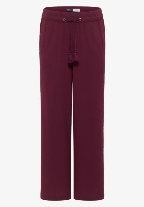 Bordeauxrote, weit geschnittene Damenhose mit Kordelzug und Quasten.