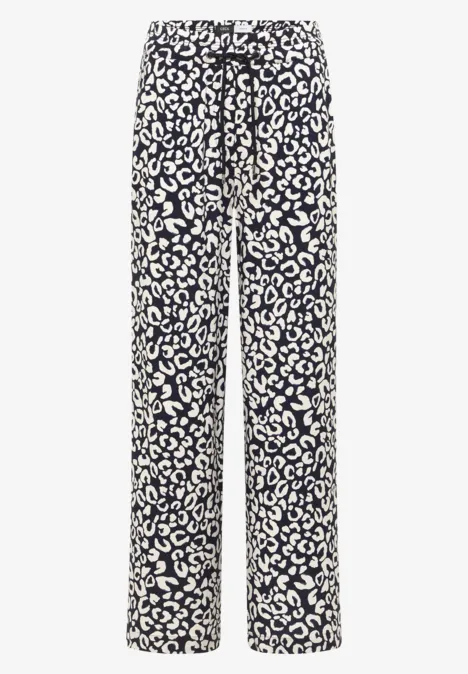 Weite Damenhose aus fließendem Stoff mit schwarz-weißem Leopardenprint.
