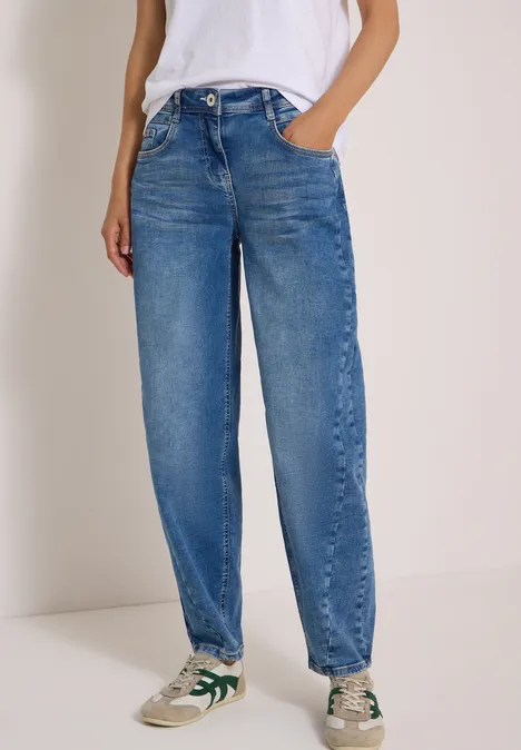 High Waist Barrel Leg Jeans im Loose Fit light blue used wash Person trägt lockere, hoch taillierte blaue Jeans und weiße Sneaker mit grünen Akzenten.