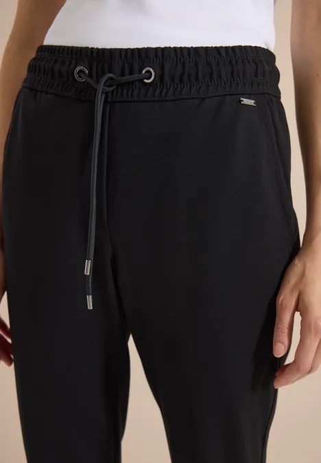 Schwarz figurbetonte Sweatpants mit elastischem Bund und Kordelzug, kombiniert mit weißem Oberteil.