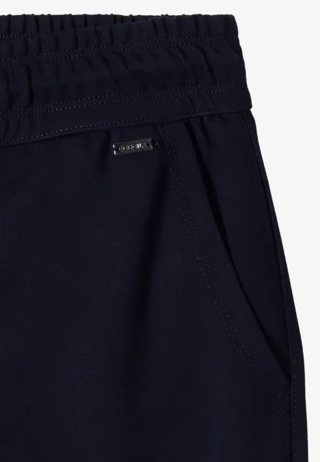 Dunkelblaue Jogginghose mit elastischem Bund und seitlicher Eingrifftasche, kleines Markenlogo.