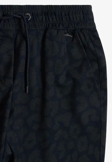Nahaufnahme einer dunkelblauen Jogginghose mit elastischem Bund und dezentem Tiermuster.