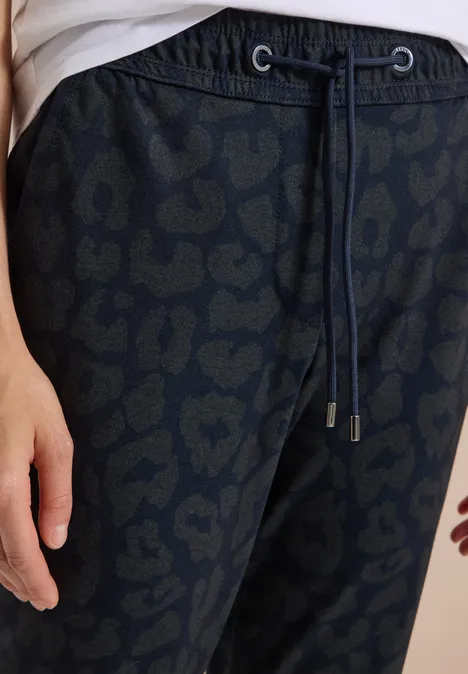Schwarze Hose mit dezentem Leopardenmuster, Kordelzug und Hand am Bund