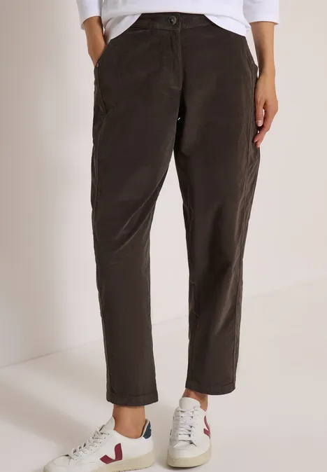 Dunkelbraune gerade geschnittene Hose mit hohem Bund, kombiniert mit weißen Sneakers.