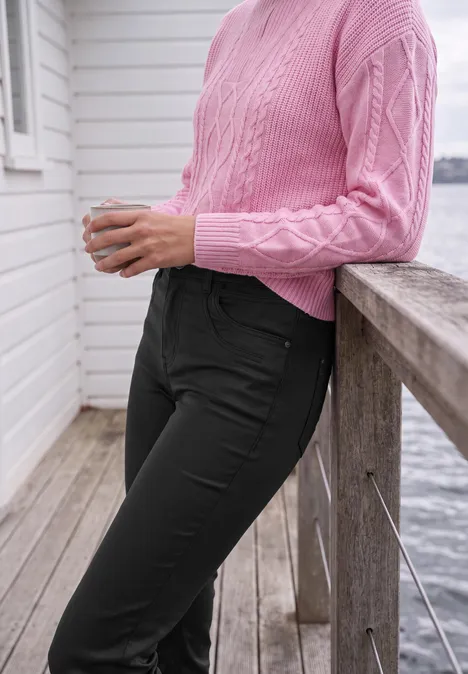 Mid Waist Straight Leg Hose im Slim Fit Black Person lehnt an hölzernem Geländer am Wasser, trägt rosa Strickpulli und schwarze Hose, hält eine Tasse.