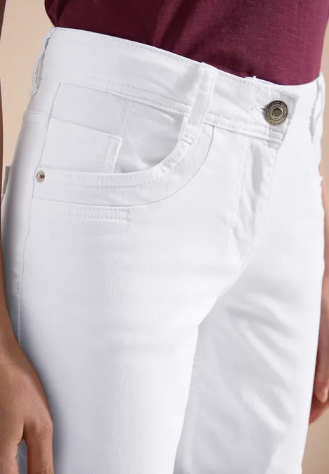Jean blanc pour femme avec poches et bouton, assorti avec un haut bordeaux.