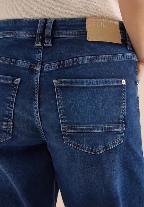 Rückenansicht einer Person in dunklen Jeans mit sichtbaren Gesäßtaschen.