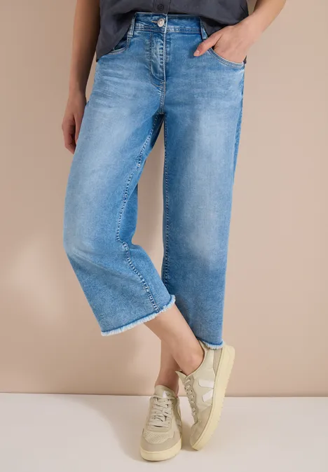 Lichtgewassen, wijde enkeljeans gecombineerd met lichte sneakers.