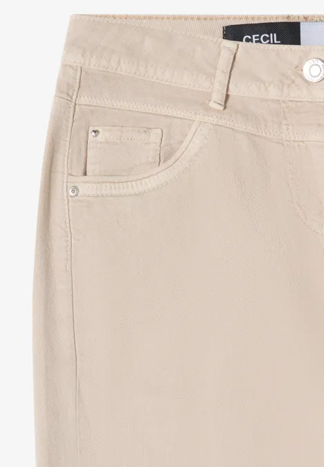 Jean femme beige à passants de ceinture avec étiquette de marque à la taille.