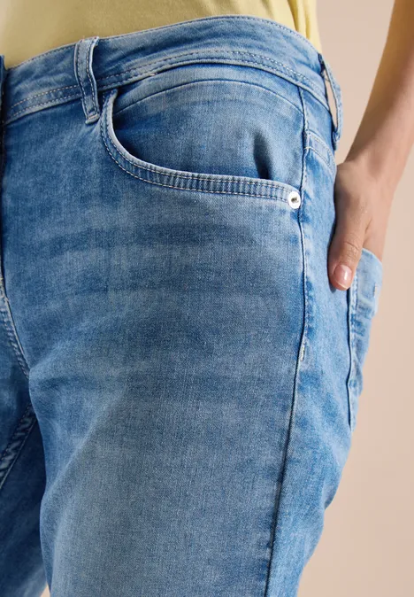 Jeans bleu délavé avec poches, vue rapprochée sur la texture.