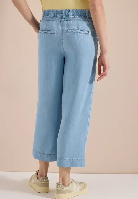 Lichtblauwe, wijdvallende jeans met elastische taille, kort tot op de enkels, casual look.
