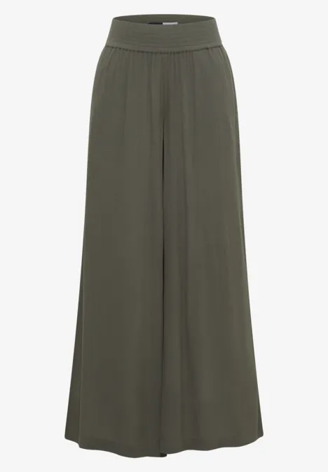 Locker geschnittene, weite Hose aus dunkelgrünem, fließendem Stoff mit breitem, elastischem Bund.