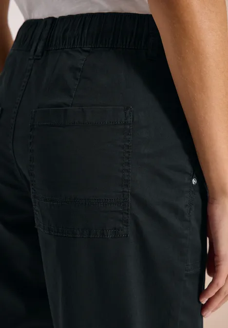 Schwarze Hose mit elastischem Bund und großflächiger aufgesetzter Gesäßtasche.