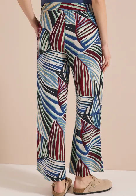 Pantalon ample à larges jambes avec motif feuilles multicolores bleu, vert, blanc et rouge.