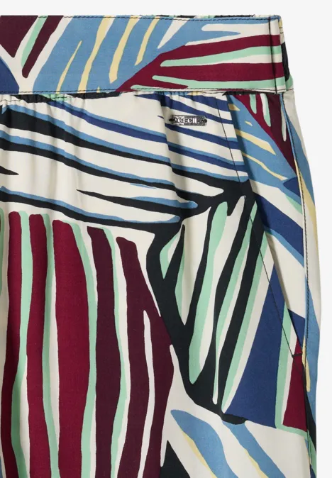 Jupe portefeuille à rayures abstraites bleu, vert et bordeaux sur fond blanc.