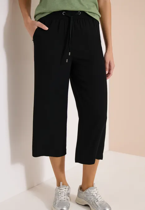 Zwarte, wijde culottebroek met trekkoord, schuine zakken en een ontspannen mid-kuit lengte.