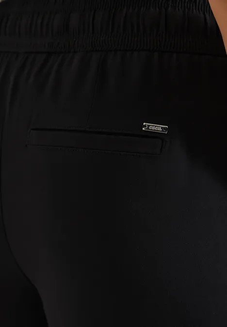 Zwarte sportbroek met achterzak met rits en merklabel.